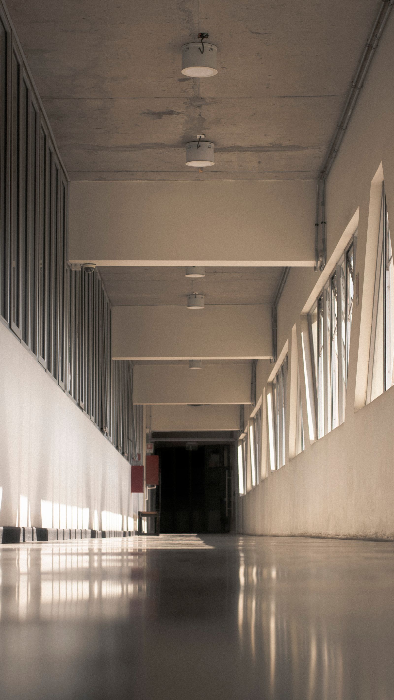 Long white service corridor with a seamless coated floor